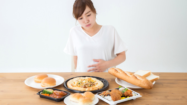 Woman holding full stomach