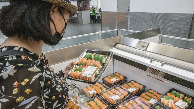 woman looks at prepared sushi