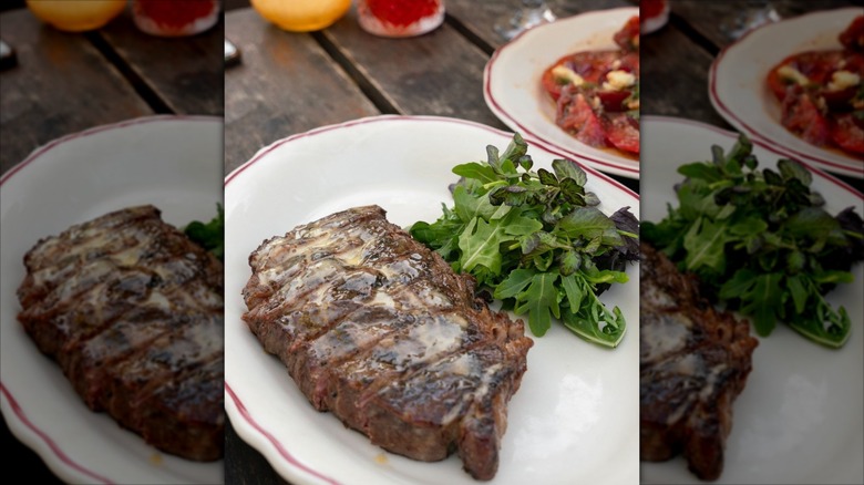 Sliced steak plated with butter and salad