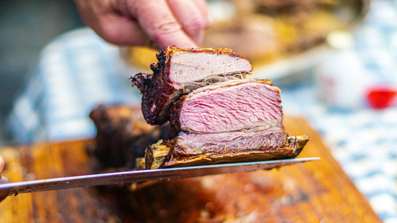 Hands slicing open steak