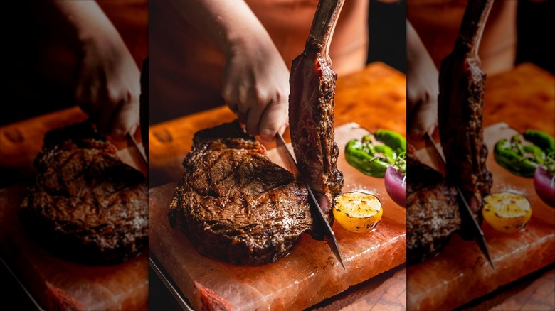 Hands slicing Tomahawk steak