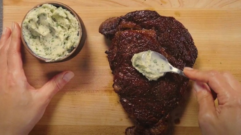 spooning truffle butter on steak