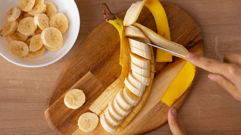 slicing banana on cutting board