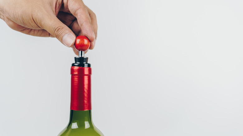 placing wine stopper on bottle