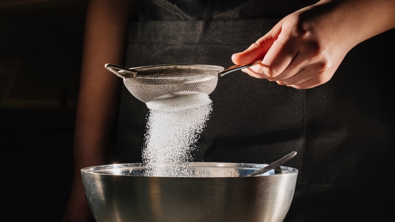 sifting powder sugar into bowl 