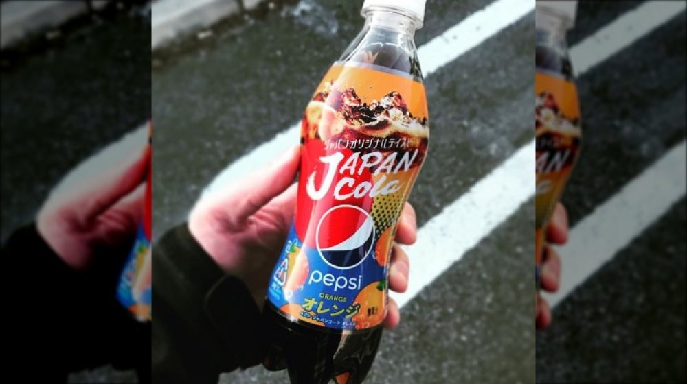 hand holding a bottle of Pepsi Orange