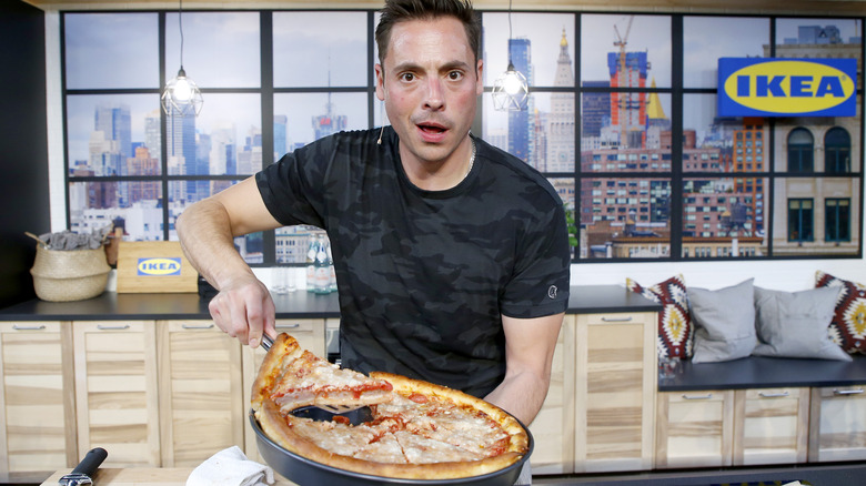 Jeff Mauro holding a pizza