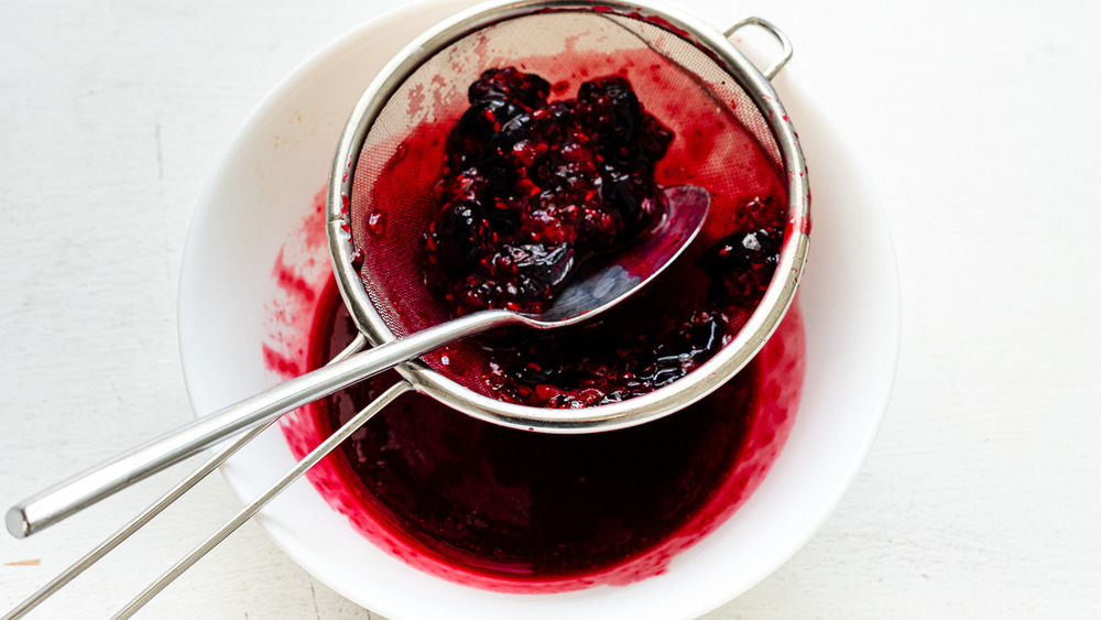 white bowl of mixed berries in a sieve for no-bake Jello cheesecake