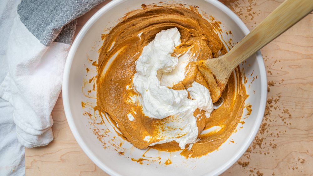 Mixing whipped cream into pumpkin