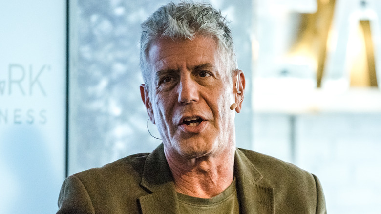 Anthony Bourdain talking with earpiece mic