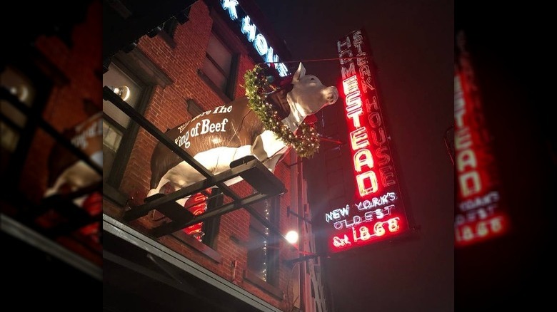 front of old homestead steakhouse with cow and sign