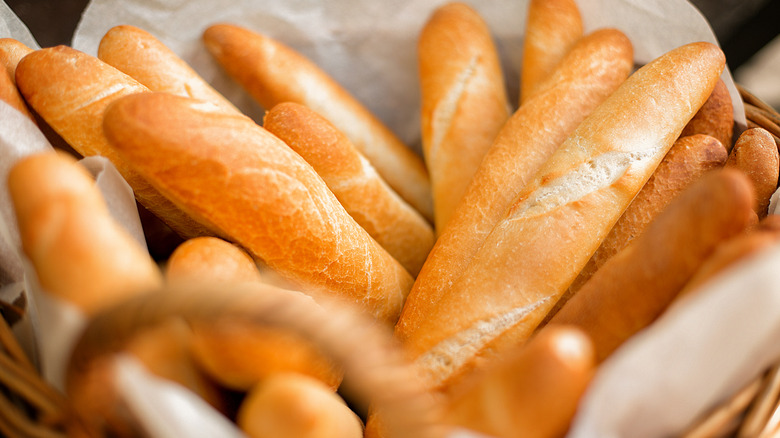 Several crusty baguettes in a basket