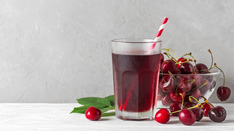 bowl of cherries and glass of cherry juice with straw