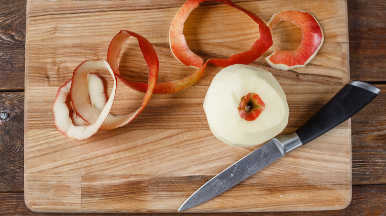 paring knife next to a peeled apple