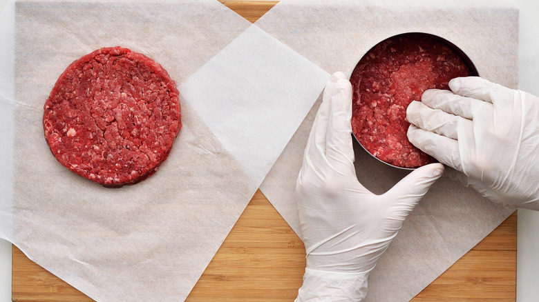 Person making hamburger patties using a ring mold