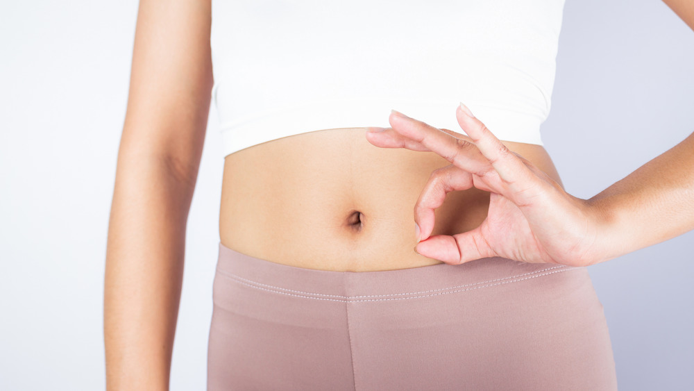 woman with her hand in an ok sign near her belly