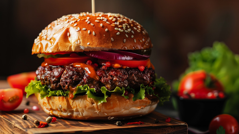 close-up of a gourmet burger with toppings on a seeded bun