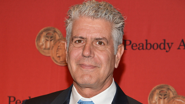 Anthony Bourdain smiles with blue tie