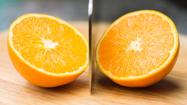 Orange sliced in half on cutting board