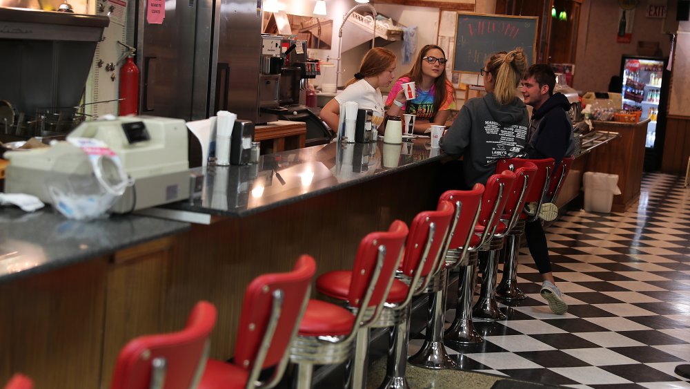 People hang out at the soda fountain counter in the Montross Pharmacy on October 10, 2019 in Winterset, Iowa. The 2020 Iowa Democratic caucuses will take place on February 3, 2020, making it the first nominating contest in the Democratic Party presidential primaries.