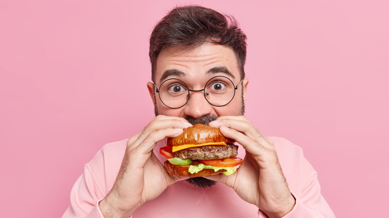 man biting into a burger