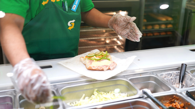 Employee prepares a sandwich