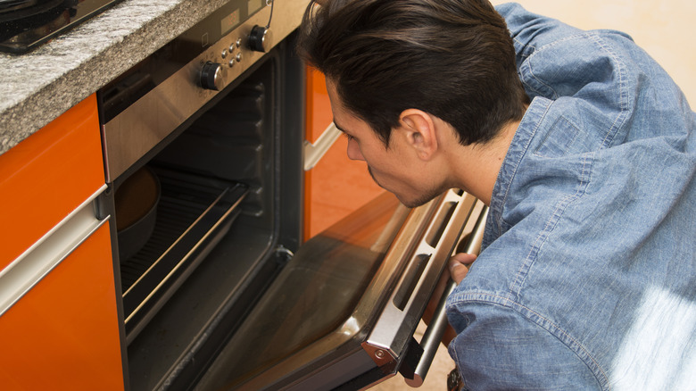 man opening oven door