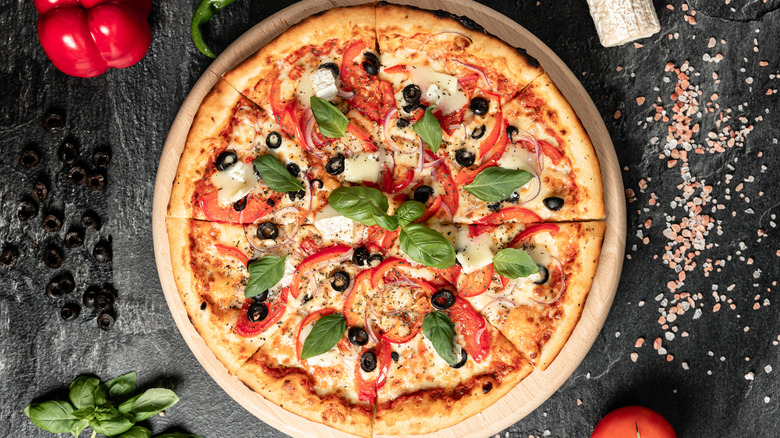 pizza with basil, olives, cheese, veggies