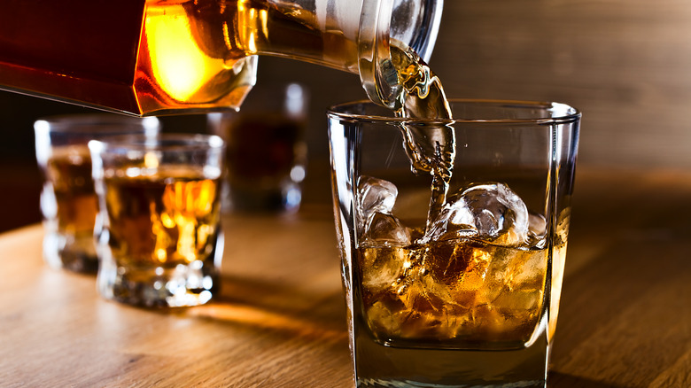 Rum pouring into rocks glass