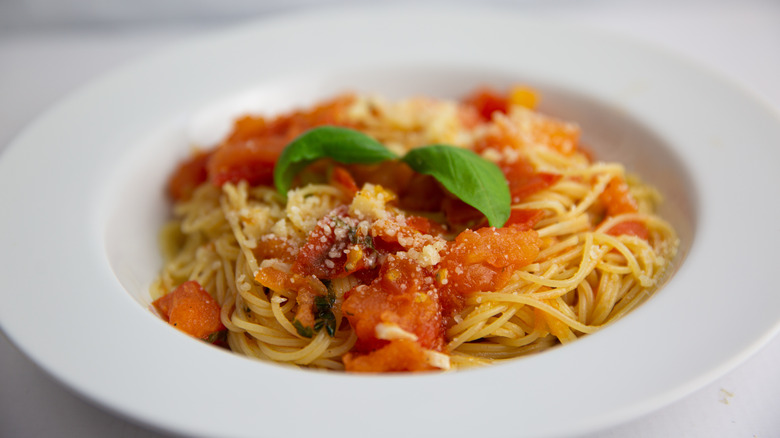 A bowl of capellini al pomodoro with basil and parmesan