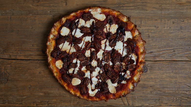 Pecan pie pizza with drizzle of glaze on a wooden table 