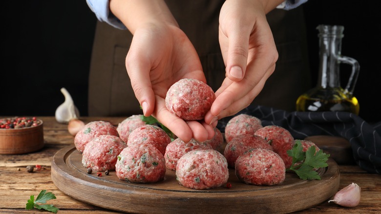 person forming meatballs