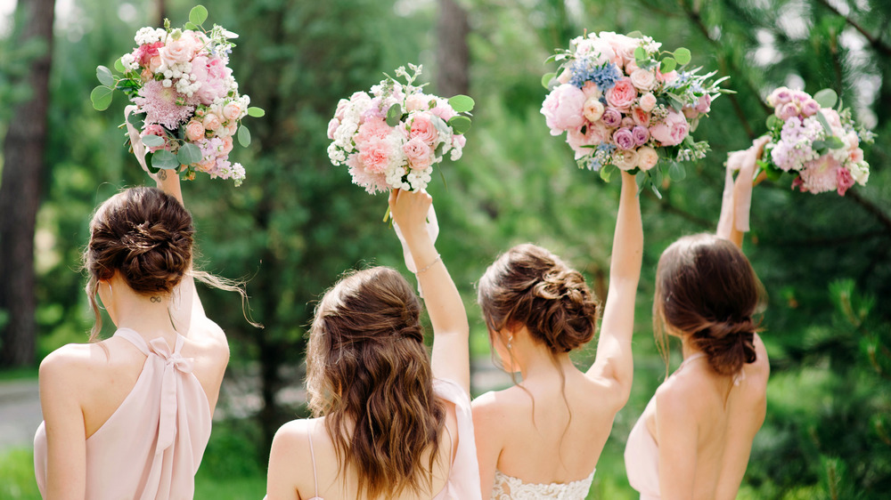 Bridal party hold up spring bouquets