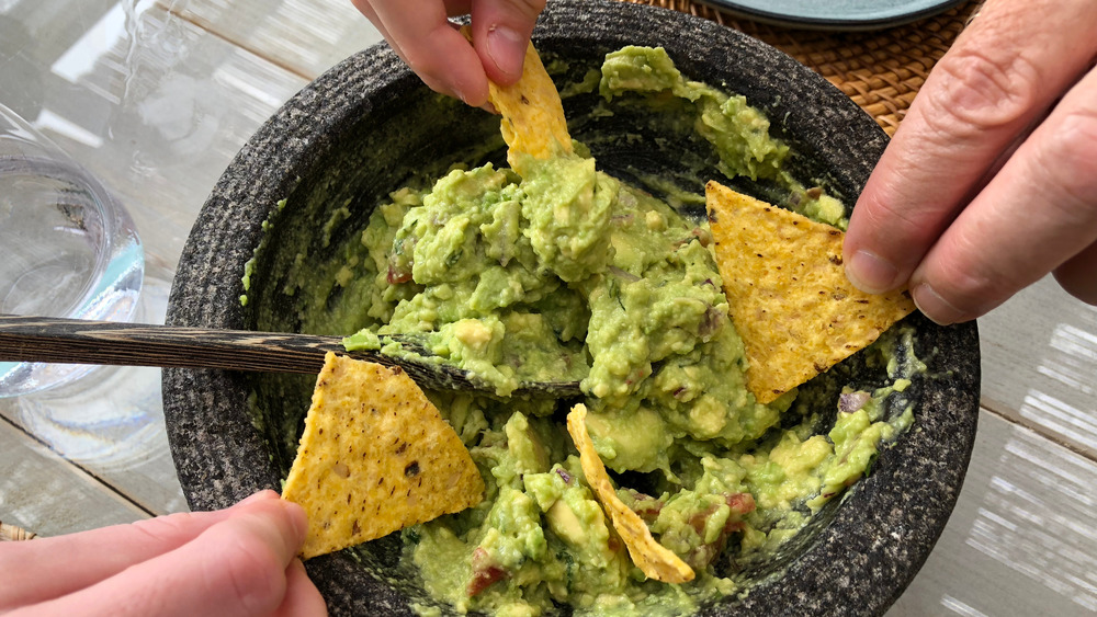 Dipping tortilla chips in guacamole