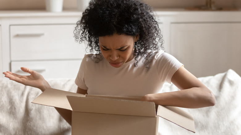 Woman looking confusedly into box 