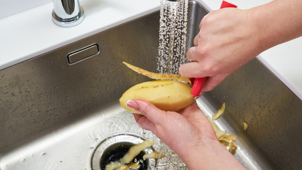 A lady peeling a potato