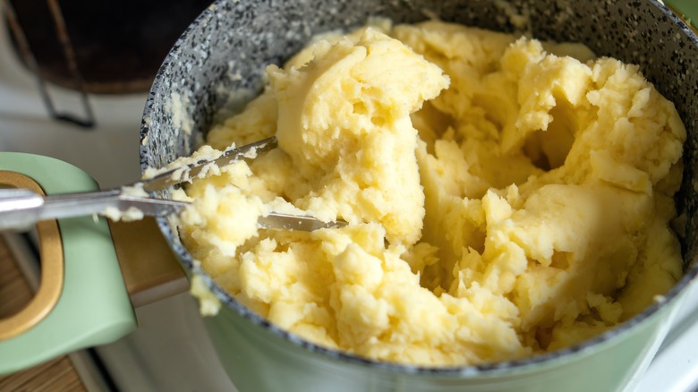 Mashing potatoes in bowl