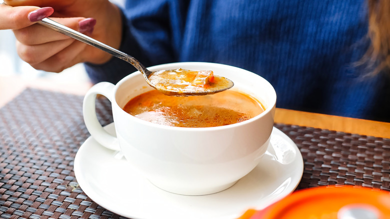 Hand with spoonful of soup