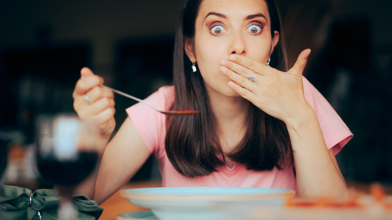 woman covering mouth while eating