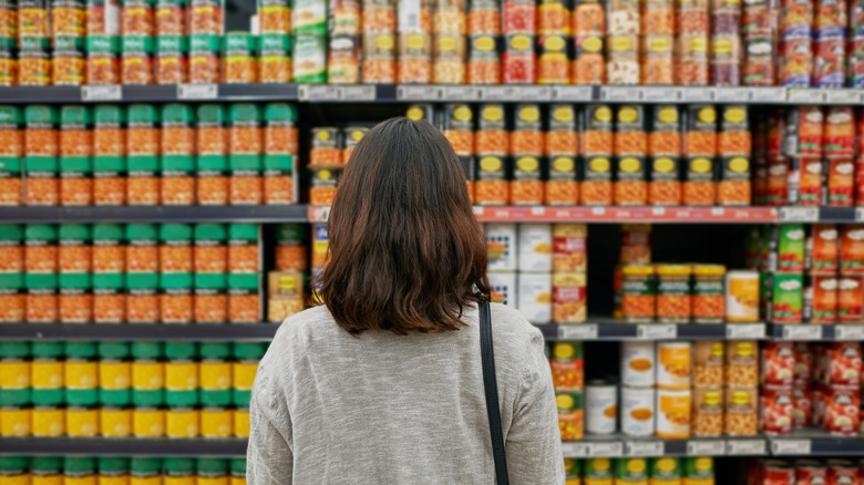 customer looking at canned foods at grocery store