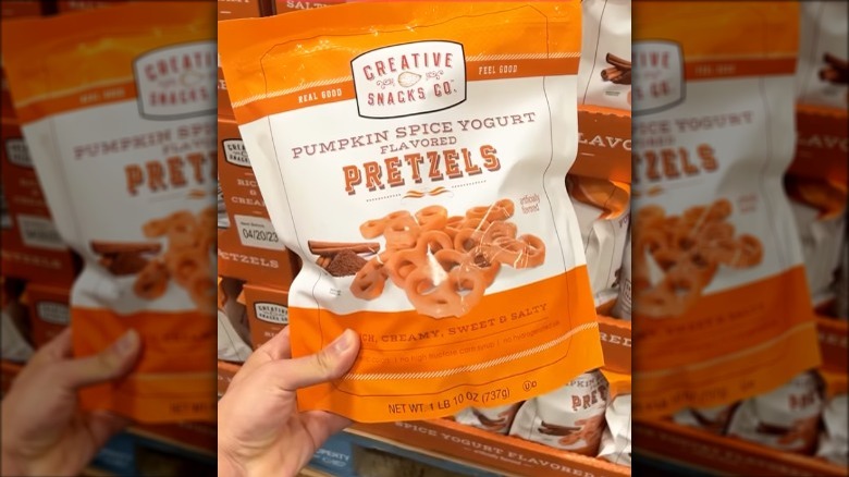 a person holding up a bag of pretzels 