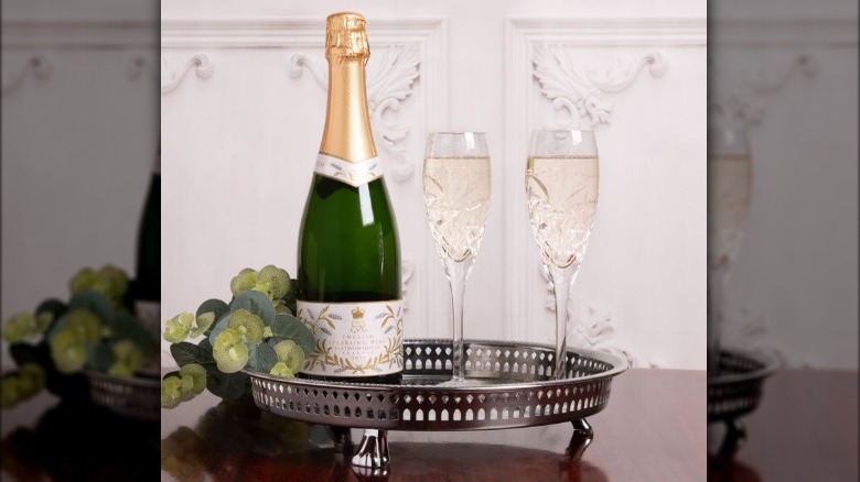 A bottle of champagne with glasses on a tray