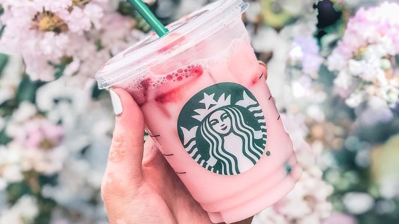 A hand holding a Starbucks Pink Drink