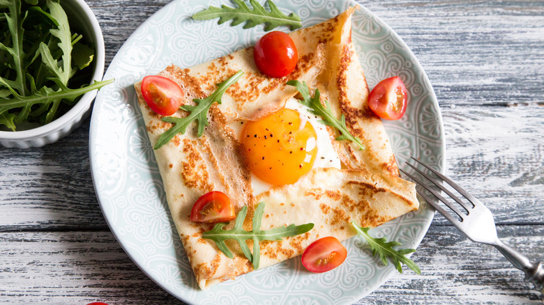 Traditional galette with egg, cherry tomatoes and arugula