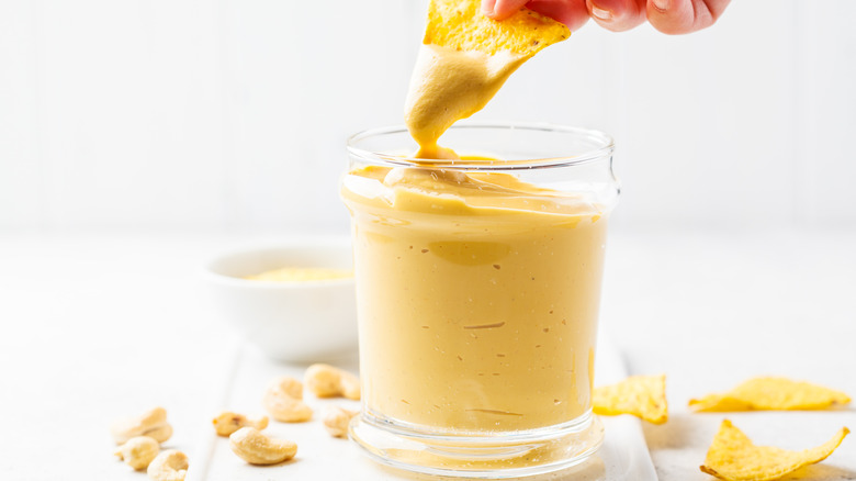 Chip being dipped into cashew cheese