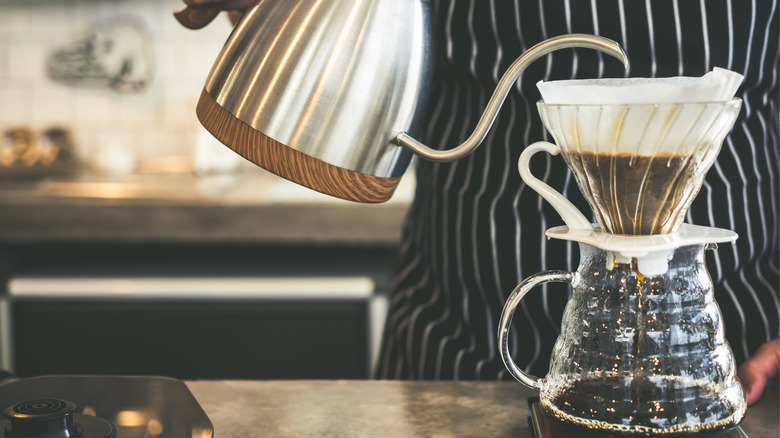 Barista brewing pour-over coffee