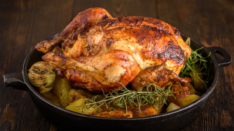 Roast chicken in a cast iron pan with potatoes