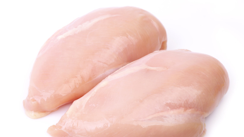 Raw chicken breasts on a white background