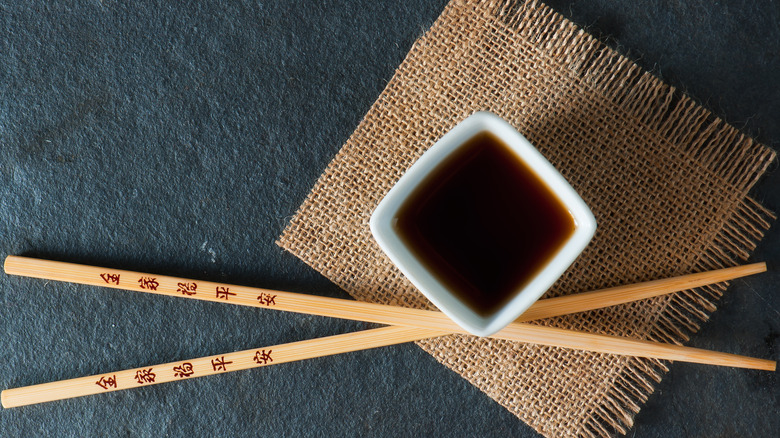 white bowl filled with hoisin sauce with chopsticks