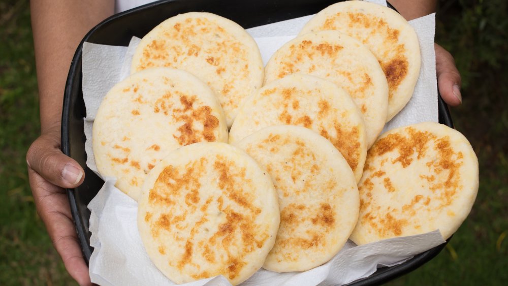 Woman holding tray of Colombia arepas